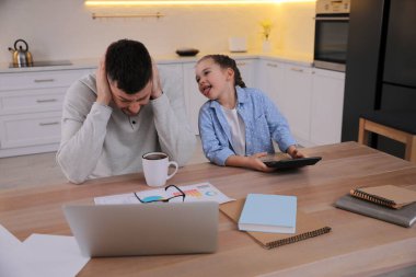 Ebeveynlik ve evde çalışmayı birleştiren bunalmış bir adam.