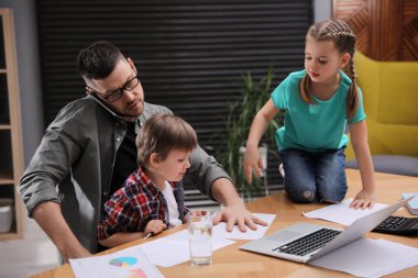 Ebeveynlik ve evde çalışmayı birleştiren bunalmış bir adam.
