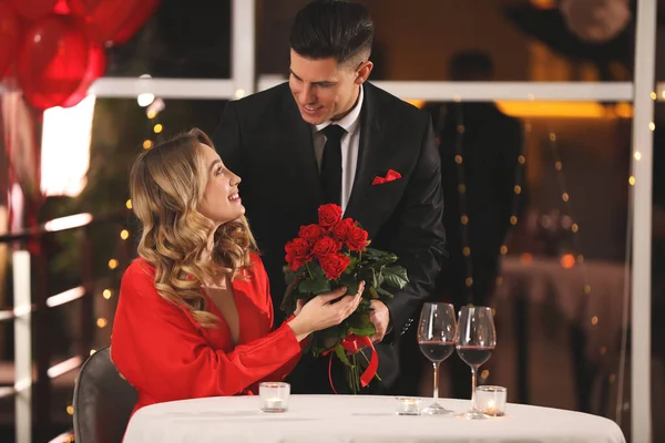 Άνδρας Παρουσιάζει Τριαντάφυλλα Στην Αγαπημένη Του Γυναίκα Στο Εστιατόριο Στο — Φωτογραφία Αρχείου
