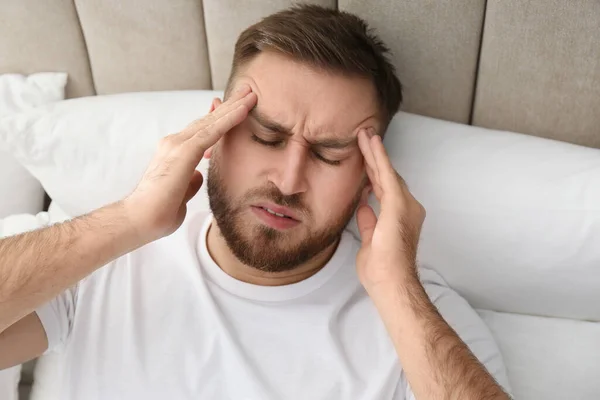 ベッドで片頭痛を患っている若い男は 上記のビュー — ストック写真