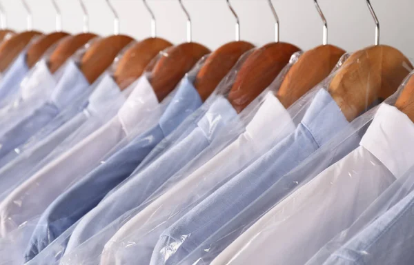 Cabides Com Camisas Sacos Plástico Limpeza Seco Rack Contra Fundo — Fotografia de Stock