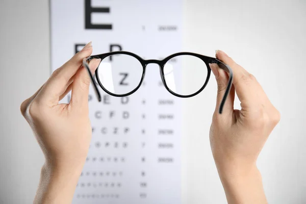 Woman Holding Glasses Eye Chart Light Background Closeup Ophthalmologist Prescription — Stock Photo, Image