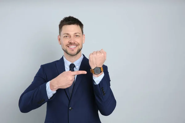 Ευτυχισμένος Επιχειρηματίας Που Δείχνει Ρολόι Χειρός Γκρι Φόντο Χώρος Για — Φωτογραφία Αρχείου