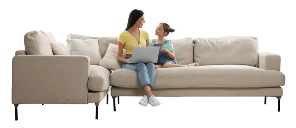 年轻的女人和她的女儿带着笔记本电脑躺在舒适的沙发上 背景是白色的 — 图库照片