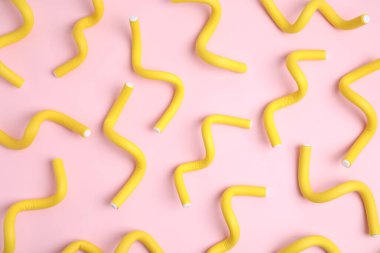 Pembe arka planda kıvrım çubukları, düz yatış. Saç şekillendirme aracı