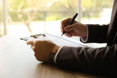 Evrakları imzalayan iş adamı, kapalı masa, yakın plan.
