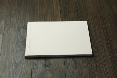Tahta masadaki boş kağıt broşürü. Tasarım için model