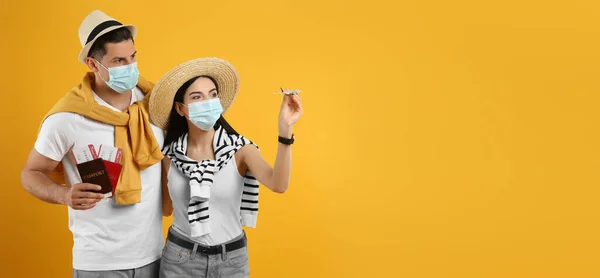 Néhány Turista Orvosi Maszkban Jegyekkel Útlevelekkel Sárga Hátterű Játékgéppel Utazás — Stock Fotó