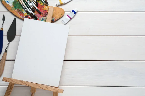 白色木制桌子上的空白帆布 工具和油漆 案文的篇幅 — 图库照片