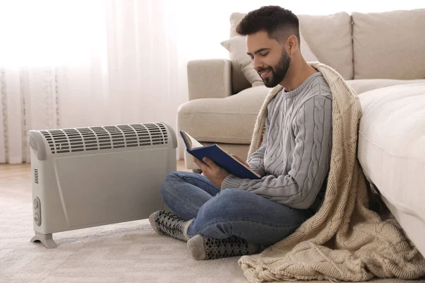 Hombre Joven Calentando Cerca Calentador Eléctrico Casa —  Fotos de Stock