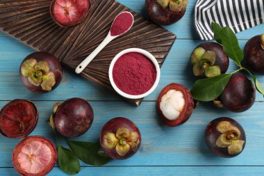 Mor mangosteen tozu ve açık mavi ahşap masa üzerinde meyveler, düz yatıyordu.