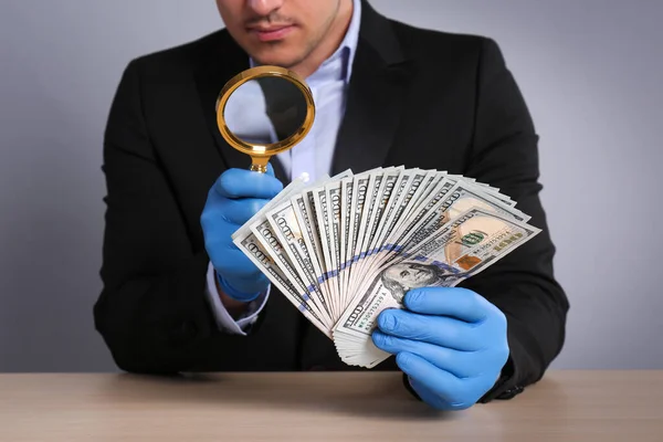 Expert Authenticeren 100 Dollar Bankbiljetten Met Vergrootglas Aan Tafel Lichtgrijze — Stockfoto