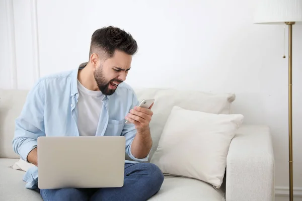 Joven Emocional Con Portátil Teléfono Inteligente Casa Concepto Odio Línea — Foto de Stock