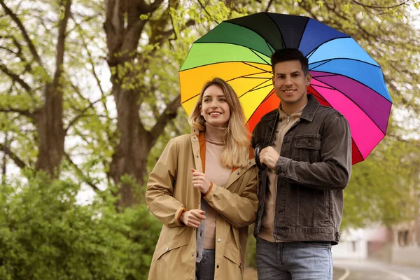 Lovely couple with umbrella walking on spring day