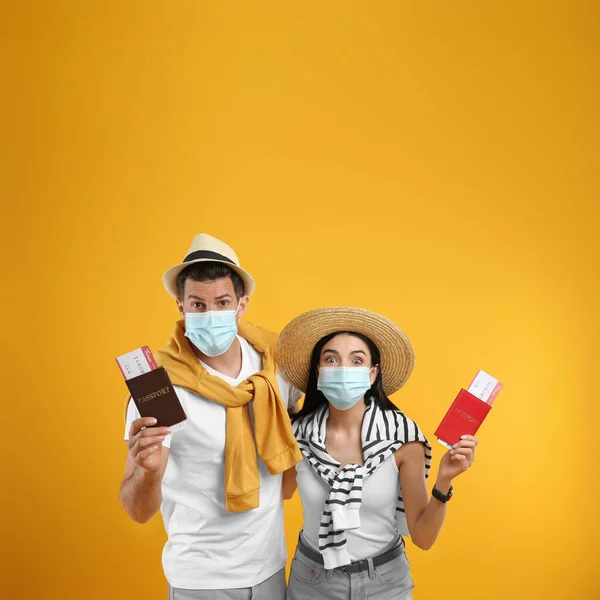 Casal Turistas Máscaras Médicas Com Bilhetes Passaportes Fundo Amarelo Viajar — Fotografia de Stock