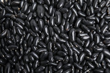 Arka plan olarak siyah fasulye yığını, üst manzara. Sebze tohumları