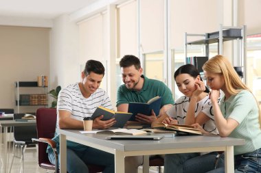 Gençler kütüphanede grup projesini tartışıyorlar