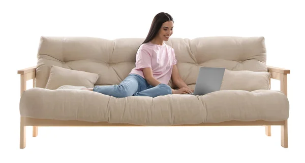 在白色背景下舒适的沙发上拿着笔记本电脑的年轻女人 — 图库照片