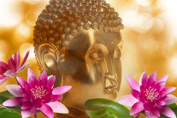 Beautiful golden Buddha sculpture and lotus flowers on color background