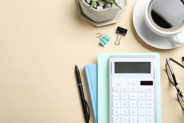 Hesap makinesi, kahve fincanı ve bej arka planda kırtasiye malzemesi ile düz konum, metin için boşluk