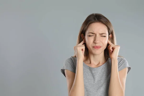 Emotionale Junge Frau Die Ihre Ohren Mit Fingern Vor Grauem — Stockfoto