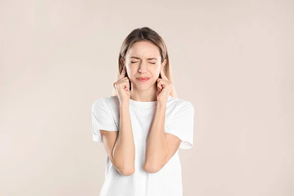 Emotional Young Woman Covering Her Ears Fingers Beige Background — Stock Photo, Image