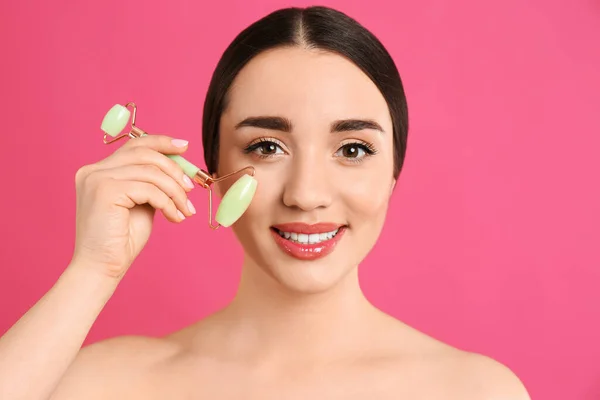 Mujer Usando Rodillo Jade Natural Sobre Fondo Rosa —  Fotos de Stock