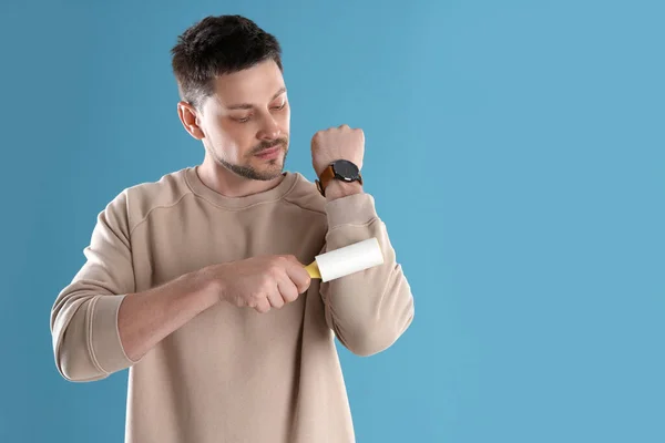 Homem Limpeza Roupas Com Rolo Fiapos Fundo Azul Claro Espaço — Fotografia de Stock