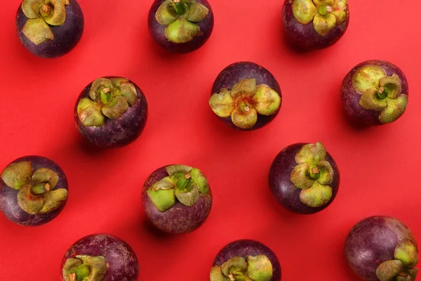 赤い背景に新鮮な熟れたマンゴスチンの果物 フラットレイ — ストック写真