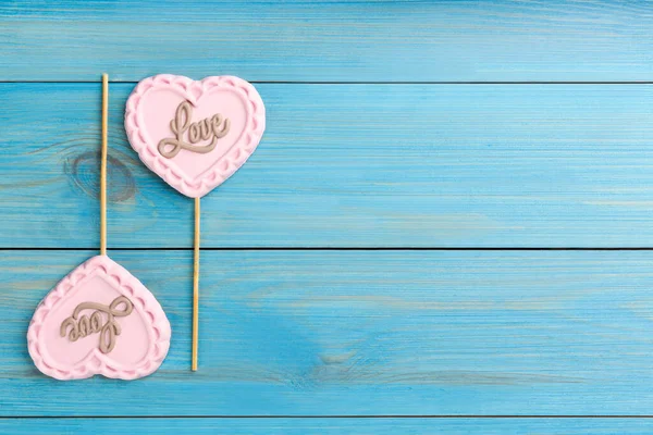 Čokoládové Lízátka Tvaru Srdce Slovem Láska Tyrkysovém Dřevěném Stole Plochá — Stock fotografie