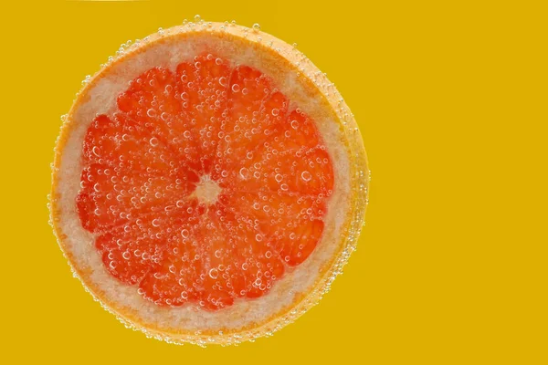 Grapefruitscheiben Sprudelndem Wasser Auf Gelbem Hintergrund Zitrusfrüchte — Stockfoto