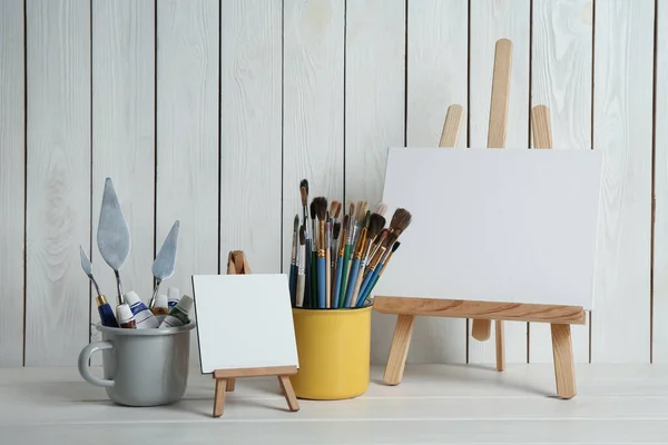 https://st2.depositphotos.com/16122460/47410/i/450/depositphotos_474105136-stock-photo-easels-blank-canvases-paints-brushes.jpg