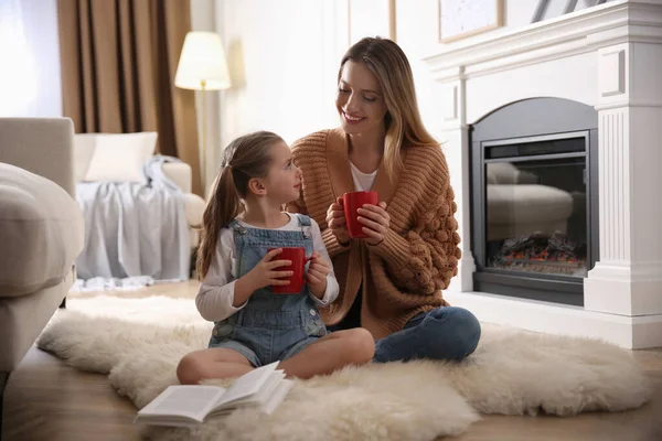 Glückliche Frau Und Ihre Tochter Mit Tassen Heißgetränk Heimischen Kamin — Stockfoto