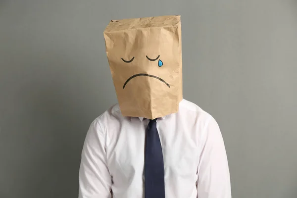Άνδρας Που Φοράει Χάρτινη Τσάντα Ζωγραφισμένο Λυπημένο Πρόσωπο Γκρι Φόντο — Φωτογραφία Αρχείου