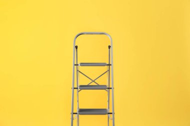 Sarı arka planda modern metal merdiven. Yapı aracı