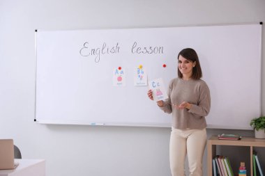 Mutlu bayan İngilizce öğretmeni içeride ders veriyor. Erken eğitim