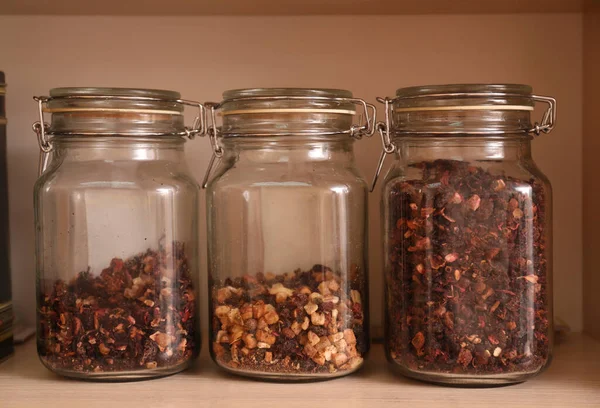 木製の棚にガラス瓶にドライフルーツスライスとお茶の異なるタイプ — ストック写真