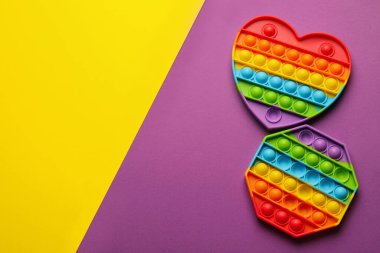 Gökkuşağı renkli arka planda hareketsiz oyuncaklar, düz yatış. Metin için boşluk