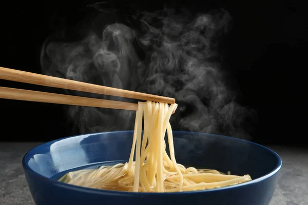 Comer Macarrão Com Pauzinhos Contra Fundo Preto — Fotografia de Stock