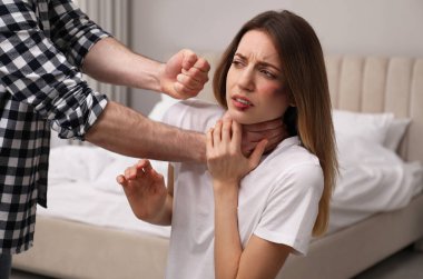 Adam, korkmuş kadını yatak odasında taciz ediyor. Aile içi şiddet