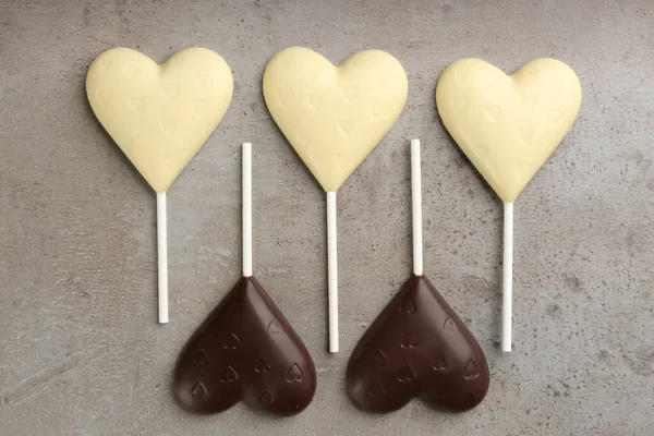 Diferentes Pirulitos Forma Coração Chocolate Mesa Cinza Flat Lay — Fotografia de Stock