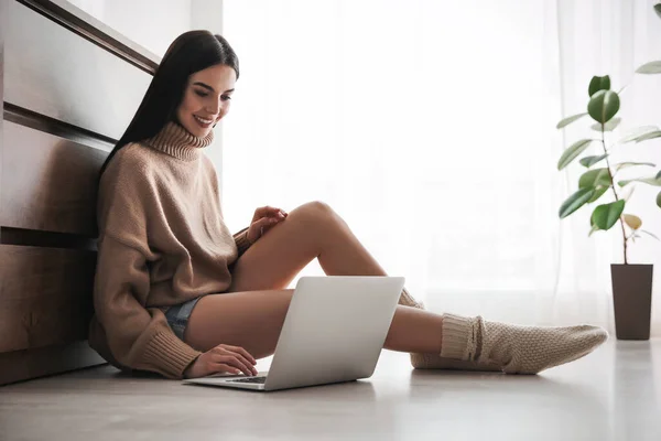 自宅の暖かい床に座ってノートパソコンを持つ女性 暖房設備 — ストック写真