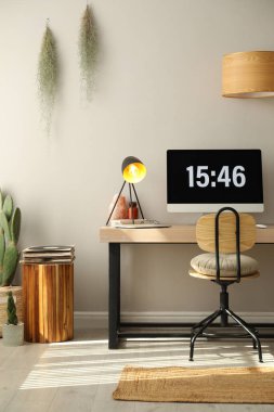 Rahat işyeri olan bir oda. Ahşap masadaki modern bilgisayar