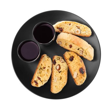 Lezzetli cantucci ile siyah tabak ve beyaz arka planda bir bardak likör, üst manzara. Geleneksel İtalyan bademli bisküvileri