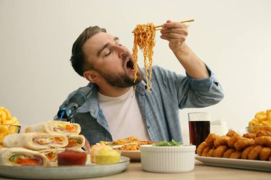 Yemek blogcusu, arka planda mikrofonun önünde yemek yiyor. Mukbang vlog