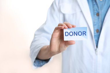 Beyaz arka planda Kelime DONOR yazılı doktor kartı, yakın plan