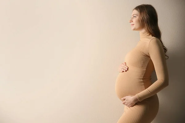 Gelukkige Zwangere Vrouw Die Haar Buik Aanraakt Beige Achtergrond Ruimte — Stockfoto