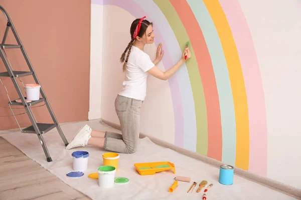 Mujer Joven Pintando Arco Iris Pared Blanca Interior — Foto de Stock