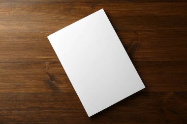 Tahta masanın üstünde boş kağıt broşür, üst manzara. Tasarım için model