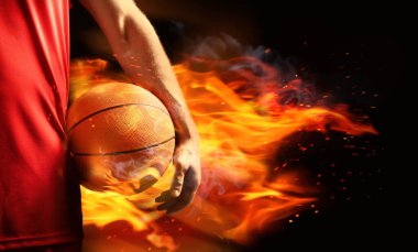 Siyah arka planda alev topu olan basketbolcu, yakın plan